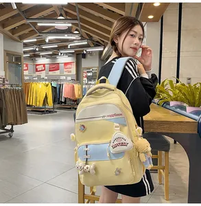 Detail of yellow and light blue backpack with cute cartoon patches and plush charms