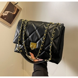 Detailansicht der schwarzen Stepptasche aus Leder mit Goldkette und Drehverschluss