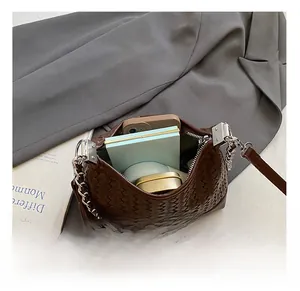 Detailed interior of brown woven leather bag showing spacious capacity for phone and makeup