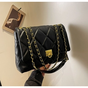 Details einer schwarzen gesteppten Ledertasche mit goldener Kette und Metallverschluss