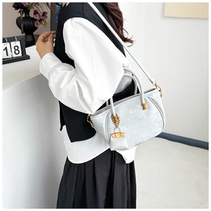 Detail of light gray textured bucket bag with ruched design and gold-tone hardware