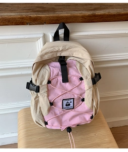 Detail of the nylon backpack featuring elastic cords, adjustable buckle, and logo patch