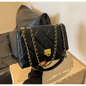 Detailaufnahme der schwarzen gesteppten Ledertasche mit goldener Kette und Metallverschluss