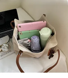 Macro view of the spacious inner compartment of the beige suede tote with leather handles
