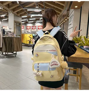 Detail of yellow Korean style backpack with cute capybara text and plush bear pendants