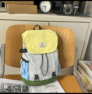 Detail of multi-color block nylon backpack on a wooden chair with vintage background