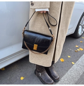 Détail du sac à rabat vintage en cuir gaufré brillant avec chaîne dorée et fermoir
