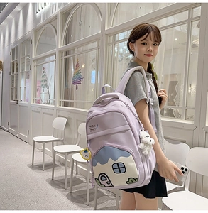 Detail of light purple waterproof nylon backpack with cute cartoon house pocket and charms
