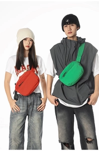 Detail of red and green nylon crossbody bags with adjustable straps and zipper pockets