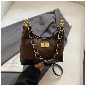 Detail of vintage quilted suede bag with gold chain strap and metallic twist lock closure