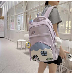 Close-up of a purple large capacity backpack with cute cartoon house prints and plush charm