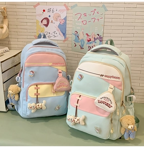 Detail of color-block canvas backpacks with capybara embroidery and cute plush charms