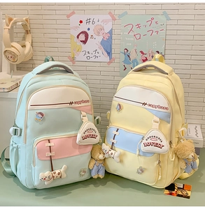 Detail of color-block school backpack with capybara embroidery and cute plush charms