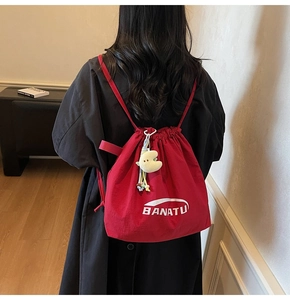 Detail eines roten Kordelzug-Rucksacks mit Banatu-Logo und gelbem Mond-Stoffanhänger