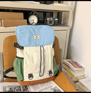 Detail of multi-color nylon backpack with buckle closure on a wooden vintage chair