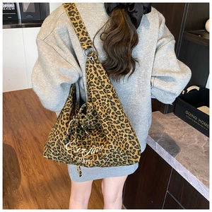 Détail du sac cabas en toile léopard avec large bandoulière et boucle à anneau métallique