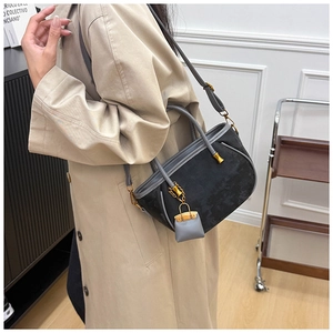 Detail of the high-quality patchwork bucket bag featuring golden hardware and mini charm