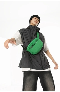 Dynamic macro view of bright green nylon crossbody chest bag on model for sporty lifestyle