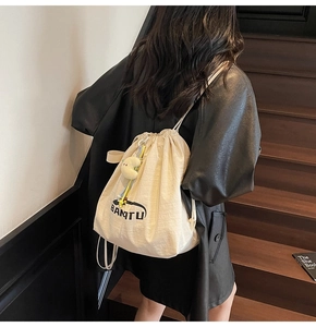 Detailansicht eines cremefarbenen Nylon-Rucksacks mit BANTU-Logo und Mond-Anhänger