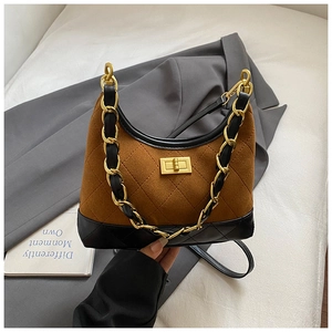 Detail of vintage caramel suede hobo bag with black quilted leather and gold chain