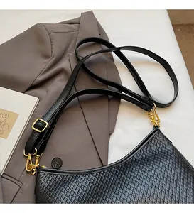 Détail du sac hobo en cuir tressé noir avec boucle dorée et bandoulière réglable