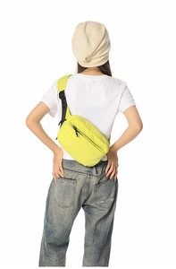 Rear view of neon yellow nylon crossbody bag with adjustable strap and multiple zip compartments
