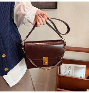 Vue détaillée d'un sac à bandoulière en cuir marron avec fermoir doré et chaîne vintage