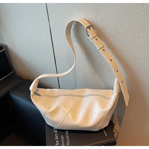 Detail of cream hobo bag showing wrinkled leather texture and adjustable strap buckle