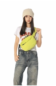 Neon green nylon crossbody bag showing multiple zip compartments and stylish street fit