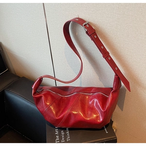 Detailed close-up of dark red oil wax leather handbag with parallel stitching and silver hardware