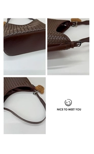 Close-up of woven bucket bag details with zipper, metal buckle, and cute bear charm