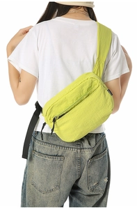 Close-up of vibrant neon green nylon crossbody bag with multi-zippered compartments