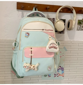 Detail of light blue and pink water-resistant nylon backpack with cute plush cat charms