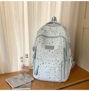 Detail of light blue waterproof backpack with star patterns and front zipper pocket