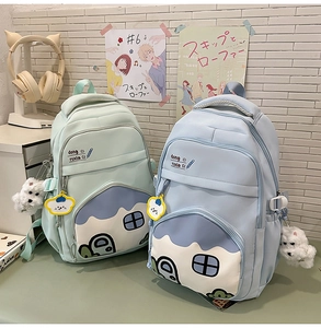 Detail of cute school backpack with pastel house pocket and white puppy charm