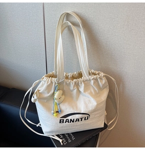 Weiße Nylon-Tasche mit Kordelzug, schwarzem Logo und buntem Plüsch-Wolkenanhänger