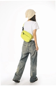 Close-up of neon yellow nylon crossbody bag with textured fabric and adjustable strap