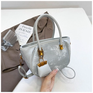 Detail of light blue bucket bag with vintage metallic texture and gold hardware