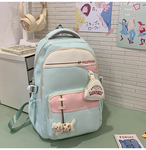 Detail of light blue school backpack with pink accents and cute cat plush charm