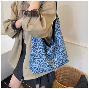 Détail du sac fourre-tout à motif léopard bleu avec nœud latéral et lettrage d'art