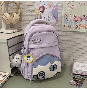Detailed view of lavender student backpack with cute cartoon house and plush puppy charm