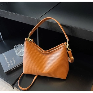 Détail du sac cabas caramel avec texture tressée, boucles dorées et bandoulière réglable
