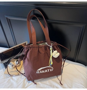 Braune Nylon-Beuteltasche mit Kordelzug, Plüsch-Anhängern und Logo für tägliches Pendeln