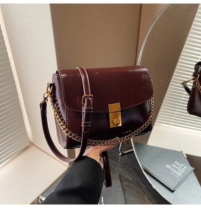 Détails du sac bandoulière en cuir rouge vin foncé avec boucle dorée et chaîne