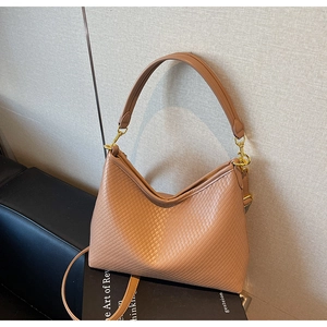 Vue détaillée du sac kaki avec texture tissée, boucles dorées et options de double bandoulière