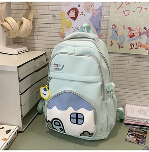 Detail of mint green school backpack with house-shaped pocket and cute bear charm