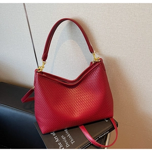 Détail du sac hobo rouge avec texture tressée en losange et finitions dorées