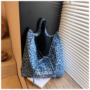 Détail du sac cabas à imprimé léopard bleu avec texte Our fave Party et nœud décoratif