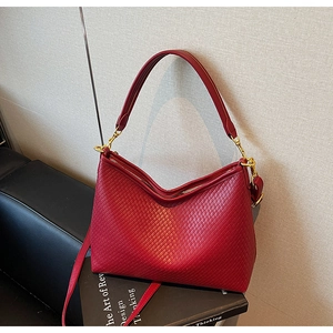 Détail du sac cabas rouge tissé avec texture matelassée et garnitures dorées chic