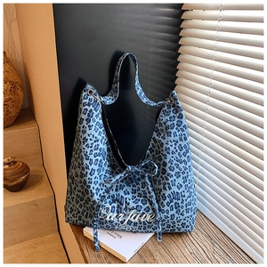 Détail du sac cabas à imprimé léopard bleu avec broderie et œillets métalliques